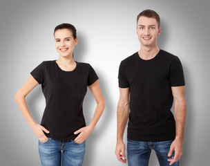 Wall Mural - Shirt design and people concept - close up of young man and woman in blank black t-shirt front and rear isolated.