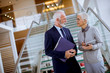 © BGStock72 - Senior businessman  holding documents and businesswoman holding tablet computer were discussing jobs in modern office