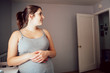 Pregnant Woman Stands in Nursery 