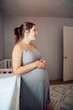 Pregnant woman stands in nursery