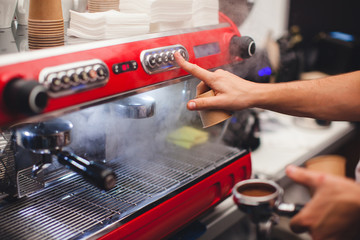 A barista in a coffee machine makes coffee