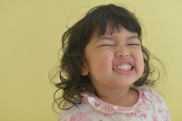 Portrait of a smiling happy little cute girl showing her perfect smile and her laughing.