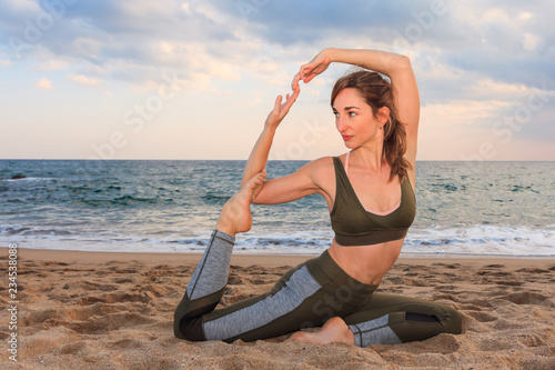 Fotografie, Obraz Yoga asana on the beach: girl training in Kapotasana pose