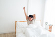 © Asada - Asian handsome man waking up in the early morning. Outstretched arms. People always stretch after they get up in the morning