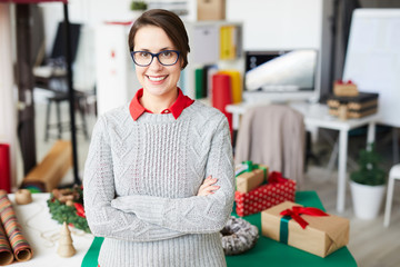 Young smiling businesswoman in smart casualwear and eyeglasses looking at you in studio