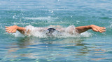 Fototapeta Łazienka - Muscular young man swimming butterfly stiles