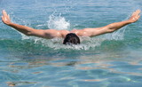 Fototapeta Łazienka - Muscular young man swimming butterfly stiles