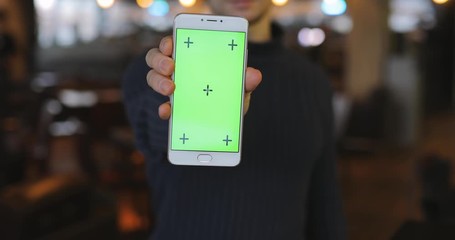 Man showing green screen of smartphone, empty digital display