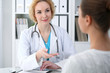© rogerphoto - Happy blonde female doctor and patient discussing medical examination results. Medicine, healthcare and help concept