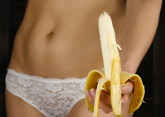 Young woman peeling banana in a white panties. close-up buttocks and hip.