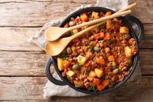 Delicious Picadillo cooked from ground beef with vegetables, raisins and spices close-up in a frying pan. horizontal top view
