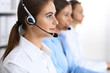 © rogerphoto - Call center. Group of operators at work. Focus at beautiful business woman in headset