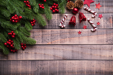 Christmas background concept. Top view of Christmas gift box red sock with spruce branches, pine cones, red berries and bell on old wooden background.