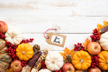 Wall Mural - top view of autumn maple leaves with pumpkin and red berries on white wooden background. thanksgivin