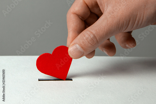 Cuadros en Lienzo Man’s hand places heart in the donation slot