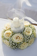 Composizione floreale di rose con al centro una candela dentro un bicchiere di vetro trasparente
