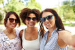 © Syda Productions - female friendship, people and leisure - happy young women in sunglasses at summer park