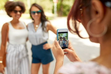 Sticker - female friendship, technology and people - woman with smartphone photographing her friends in summer park