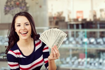 Wall Mural - Pretty young woman holding money banknotes on background