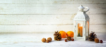 Candle Light Lantern With Pine Cones, Nuts And Tangerines As Christmas Decoration On A Wide, Bright Wooden Background, Panoramic Format With  Large Copy Space