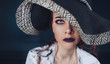 Portrait of a girl in dark colors. Model in a hat, expressive eyes