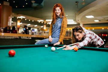 Wall Mural - Happy young friends playing snooker and billiards