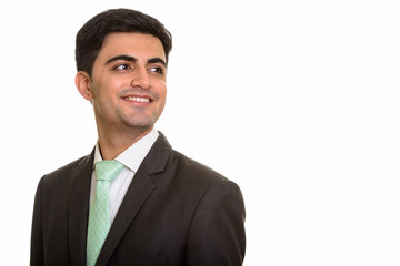 Young happy Persian businessman smiling and thinking