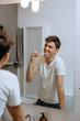 © cherryandbees - man brushing his teeth in bathroom