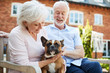 © Monkey Business - Retired Couple Sitting On Bench With Pet French Bulldog In Assisted Living Facility