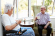 © Monkey Business - Male And Female Residents Sitting In Chairs and Talking In Retirement Home