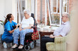 © Monkey Business - Male And Female Residents Sitting In Chair And Talking With Nurse In Retirement Home