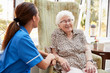 © Monkey Business - Senior Woman Sitting In Chair And Talking With Nurse In Retirement Home