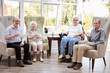 © Monkey Business - Portrait Of Male And Female Residents Sitting In Chairs In Lounge Of Retirement Home