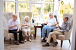 © Monkey Business - Male And Female Residents Sitting In Chairs And Talking In Lounge Of Retirement Home