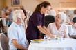 © Monkey Business - Senior Couple Being Served With Meal By Carer In Dining Room Of Retirement Home