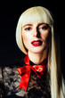 © Carlos David - Portrait of a beautiful blonde woman with red bow and black lace top. isolated on black studio background