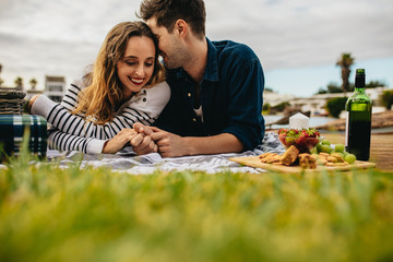 Wall Mural - Romantic couple out on picnic lying on the ground