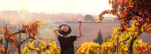 Cuadros en Lienzo Girl in a hat at sunset and a glass of wine in hand