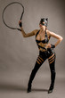 © terryleewhite - Young woman wearing a cat suit and mask with a whip