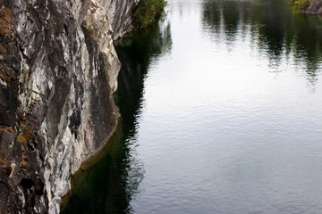 Ruskeala marble quarry, Karelia, Russia. turquoise water in the river and gray with white veins of the shore, forest.