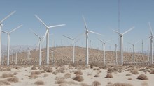 Wind Farm Desert Landscape With Wind Turbines Producing Clean And Renewable Energy. Nature Sourced Electricity, Sustainability Concept. Filmed Outside Palm Springs, California. Panning Camera Motion. 