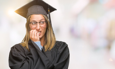 Poster - Young beautiful woman wearing graduated uniform over isolated background looking stressed and nervous with hands on mouth biting nails. Anxiety problem.