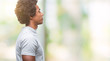 © Krakenimages.com - Afro american man over isolated background looking to side, relax profile pose with natural face with confident smile.