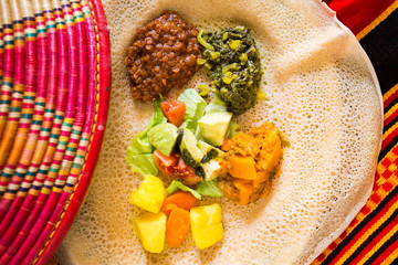 Wall Mural - Ethiopian injera with food. The injera or inyera is a very thin flatbread, similar to a crêpe, which forms the base of any Ethiopian and Eritrean meal.