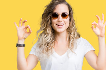 Poster - Beautiful young blonde woman wearing sunglasses over isolated background relax and smiling with eyes closed doing meditation gesture with fingers. Yoga concept.