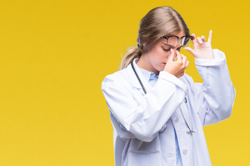 Sticker - Beautiful young blonde doctor woman wearing medical uniform over isolated background tired rubbing nose and eyes feeling fatigue and headache. Stress and frustration concept.