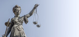 Statue a judge woman with scales and sword at smooth blue background in Frankfurt, Germany, details, closeup