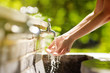 © Maria Sbytova - Woman washing hands in a city fountain