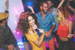 © Alessandro Biascioli - Group of friends dancing and drinking champagne at nightclub - Young happy people having fun and enjoying party eating candy lollipops - Youth friendship lifestyle concept