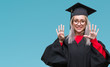 © Krakenimages.com - Young blonde woman wearing graduate uniform over isolated background showing and pointing up with fingers number nine while smiling confident and happy.